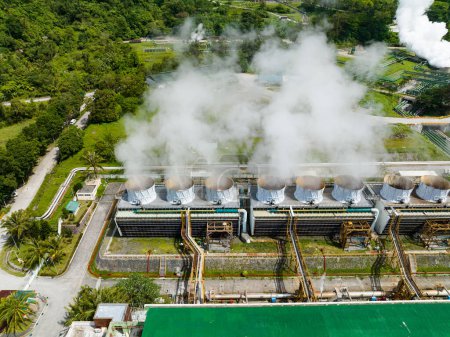 Geothermisches Kraftwerk mit rauchenden Pfeifen und Dampf. Erneuerbare Energieerzeugung in einem Kraftwerk. Negros, Philippinen.