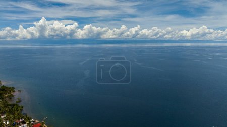 Aerial view of the island of Cebu from the sea. Blue ocean and sky with clouds. Seascape in the tropics.
