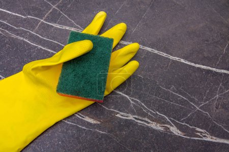Téléchargez les photos : Gant de ménage en caoutchouc jaune avec tampon à récurer sur fond de marbre - en image libre de droit