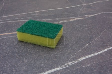 Téléchargez les photos : Une éponge de nettoyage jaune sur un plateau en marbre - en image libre de droit