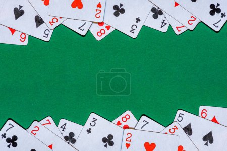 Téléchargez les photos : Jouer aux cartes sur une table de casino en feutre vert. Arrière plan avec espace de copie - en image libre de droit