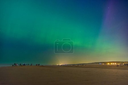 Téléchargez les photos : Aurores boréales sur la plage de Katwijk aan zee, Pays-Bas, vert Aurora borealis - en image libre de droit