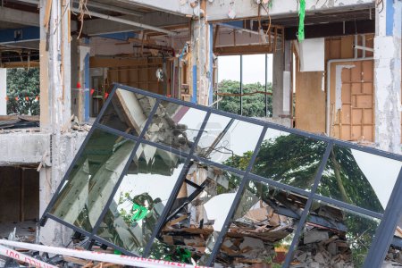Téléchargez les photos : Bâtiment municipal en projet de démolition avec structure exposée et vitres miroir réfléchissant - en image libre de droit