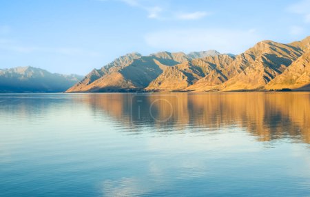 Photo for Peaceful Lake Wanaka in morning light surrounding hills and blue sky. - Royalty Free Image