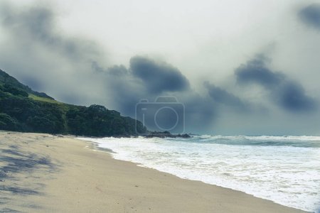 Photo for Large rough sea and rain pound coastal beach as cyclone approaches New Zealand at Mount Maunganui. - Royalty Free Image