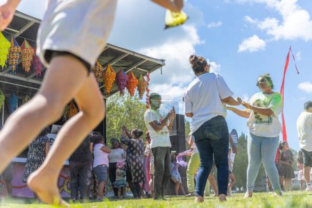 Téléchargez les photos : Tauranga Nouvelle-Zélande - 4 mars 2023 ; Des femmes couvertes de poudre colorée dansent dans la foule alors que somene traverse le festival Holi Colour Splash. - en image libre de droit
