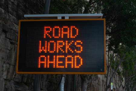 Téléchargez les photos : Travaux routiers avant panneau d'avertissement LED sur la rue de la ville. - en image libre de droit