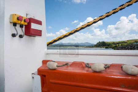 Foto de Cuerda amarilla y negra diagonal que conduce a botones de parada de emergencia con balsa salvavidas y flotadores. - Imagen libre de derechos