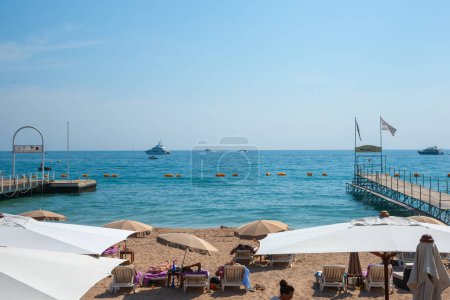 Téléchargez les photos : Cannes, Côte d'Azur, France - 4 mai 2011 ; bains de soleil pour les vacanciers méditerranéens sur la plage entre les jetées et sous les parasols Cannes - en image libre de droit