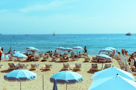 Téléchargez les photos : Cannes, Côte d'Azur, France - 4 mai 2011 ; bronzer les vacanciers méditerranéens sur la plage sous les parasols Cannes - en image libre de droit