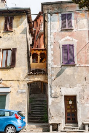 Photo for Cima Italy - May 5 2011; Editorial- Back of modern car parked below traditional old rustic three story apartment building. - Royalty Free Image