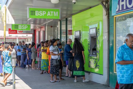Téléchargez les photos : Sigatoka Fidji - 8 septembre 2023 ; longue file d'attente ou file d'attente de personnes dans la rue faisant la queue devant le guichet automatique pour obtenir de l'argent. - en image libre de droit