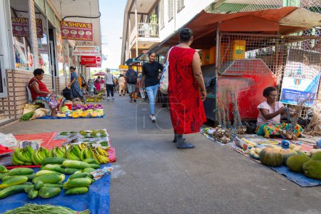 Téléchargez les photos : Sigatoka Fidji - 8 septembre 2023 ; Les gens gagnent leur vie en vendant des produits disposés pour la vente sur des feuilles de plastique sur un sentier piétonnier - en image libre de droit