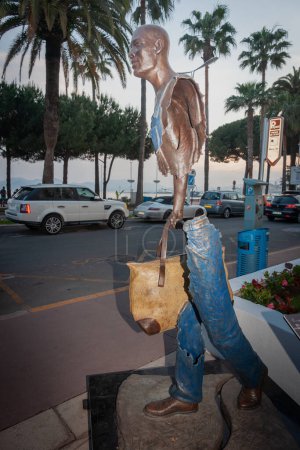 Photo for Cannes France - May 2 2011; Bronze cutaway statue on display outdoors of man wearing jeans and carrying a bag walking. - Royalty Free Image