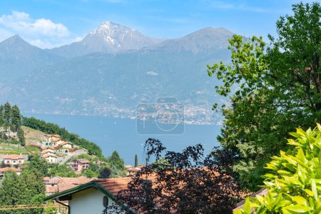 Téléchargez les photos : Vue sur les toits et bleu du lac de Côme aux montagnes italiennes pittoresques, - en image libre de droit