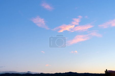 Foto de Cielo nocturno con nube rosa contra cielo azul sobre tierra baja en silueta para un fondo natural perfecto - Imagen libre de derechos