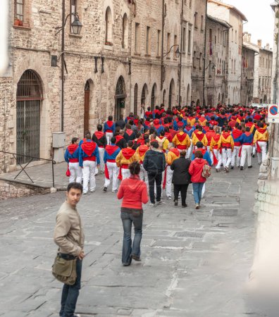 Foto de Gubbio Umbría, Italia-15 de mayo de 2011; Gente vestida con uniforme tradicional caminando calle abajo hacia el evento de celebración. - Imagen libre de derechos