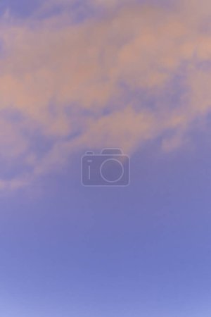 Sky and cloud background in blue and pink sunrise colours.