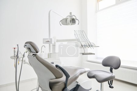 Téléchargez les photos : Intérieur de bureau du dentiste avec chaise moderne et équipement dentaire spécial - en image libre de droit