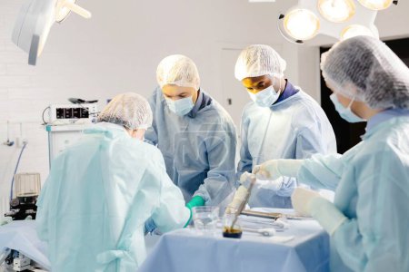 Group of doctors performing surgery in hospital.