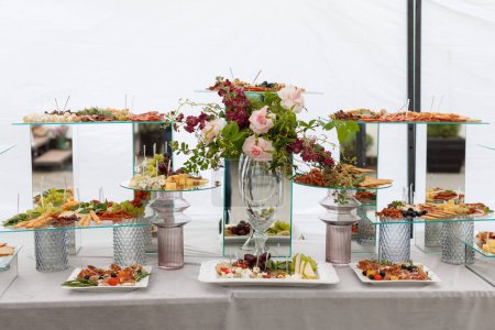 Una mesa cubierta con una variedad de diferentes tipos de alimentos, que van desde frutas y verduras hasta carnes y pasteles, creando una pantalla colorida y apetitosa.