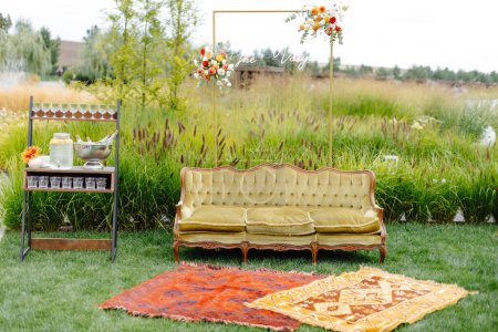 A couch placed on top of a vibrant green field, contrasting sharply against the natural surroundings.