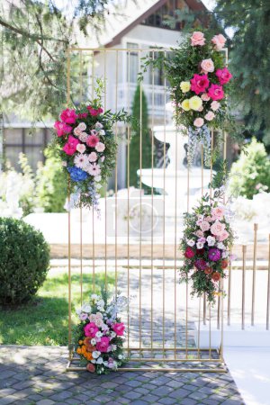 Two vibrant flowers are blooming from the metal bars of a gate, adding a touch of color and life to the sturdy structure.