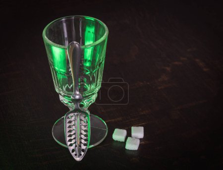 Photo for Traditional Absinthe glass and spoon with sugar cubes on wooden table - Royalty Free Image