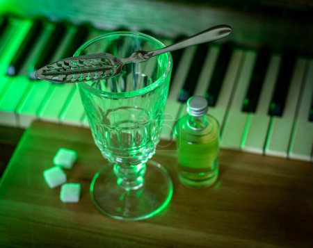 Photo for Drinking absinthe using traditional method with slotted spoon, authentic glassware and sugar cubes, selective focus - Royalty Free Image