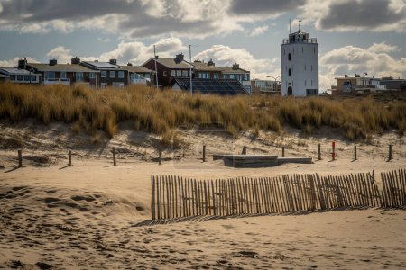 Téléchargez les photos : Phare blanc à la station balnéaire Katwijk aan Zee à partir de la plage de sable - en image libre de droit
