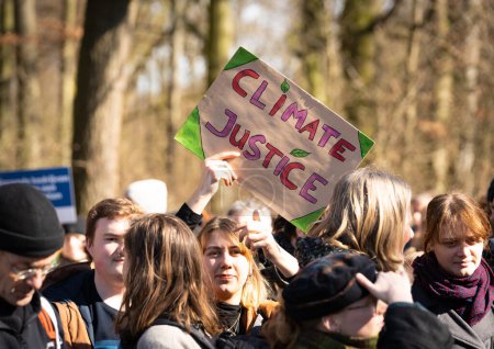 Foto de La Haya, Países Bajos, 11.03.2023, Niña sosteniendo una pancarta que dice "Justicia climática" durante la protesta del movimiento Rebelión de la Extinción contra los subsidios fósiles - Imagen libre de derechos
