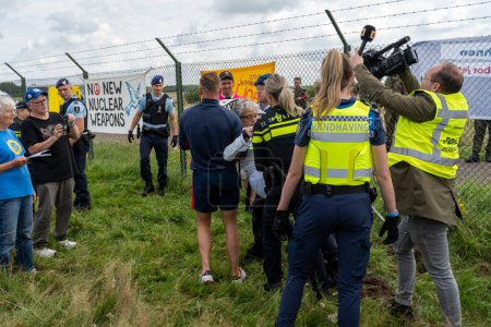 Foto de Volkel, Países Bajos, 09.08.2023, Policía arresta a un activista por intentar cavar un agujero bajo la valla de una base aérea militar holandesa durante una acción de protesta contra las armas nucleares - Imagen libre de derechos