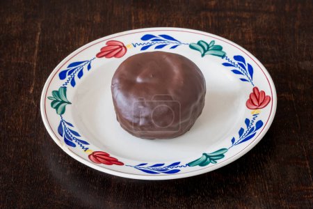 Pâtisserie traditionnelle hollandaise connue sous le nom de Bossche bol sur l'assiette, boule enrobée de chocolat remplie de crème fouettée
