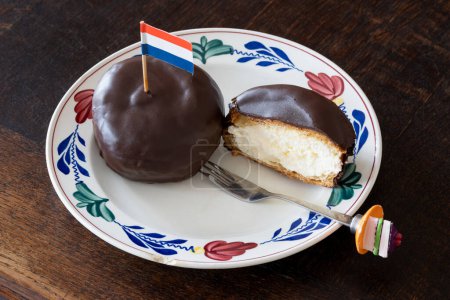 Bossche Bol dekoriert mit holländischer Flagge, typisches holländisches Gebäck bestehend aus mit Schokolade überzogener Kugel gefüllt mit Schlagsahne