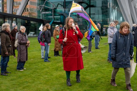 Foto de Amsterdam, Países Bajos, 30.03.2024, Activista con bandera de orgullo de progreso lgbt durante la acción de protesta de activistas climáticos del movimiento Rebelión de la Extinción - Imagen libre de derechos