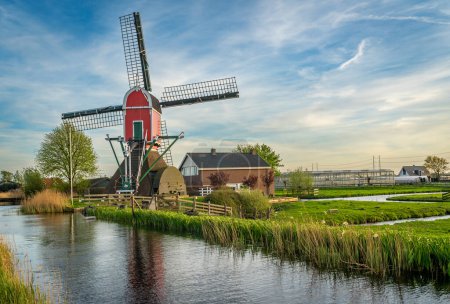 Téléchargez les photos : Moulin à vent traditionnel hollandais Rooie Wip dans le village de Hazerswoude-Dorp, Province Hollande méridionale - en image libre de droit