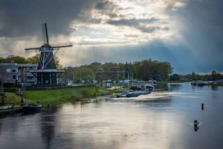 Foto de Ciudad de Ommen, Overijssel, Países Bajos. Vista del molino de viento histórico y el río Vechte - Imagen libre de derechos