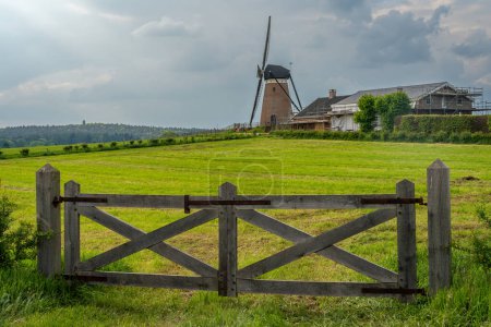Traditionelle holländische Windmühle namens Dffels Mill im Dorf Stokkum und Wachturm Montferland im Hintergrund
