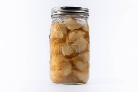Vidrio, frasco enlatado con corte, patatas sobre fondo blanco.