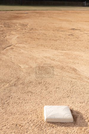 Téléchargez les photos : Une base sur un terrain de baseball dans la terre. Fond de baseball. - en image libre de droit