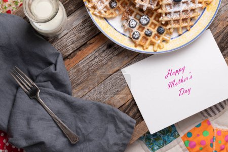 Photo for Waffles, blueberries, and milk on a wooden serving tray with a Happy Mother's Day card.  Breakfast in bed. - Royalty Free Image