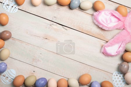 Fondo de vacaciones de Pascua con huevos multicolores sobre un fondo de tablón encalado.