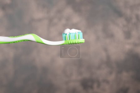 Téléchargez les photos : Brosse à dents verte et blanche avec dentifrice blanc. Concept de sensibilisation à la santé dentaire. - en image libre de droit