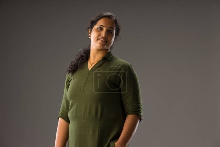 Photo for Portrait of an Indian woman,Standing pose showing different gesters, with grey background ,isolated. - Royalty Free Image