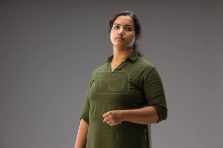 Téléchargez les photos : Portrait d'une femme indienne, pose debout montrant différents gesters, avec fond gris, isolé. - en image libre de droit