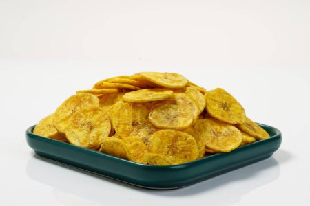Photo for Kerala chips or Banana chips, cult snack item of Kerala, arranged in a green ceramic square shaped plate ,Isolated image with white background - Royalty Free Image