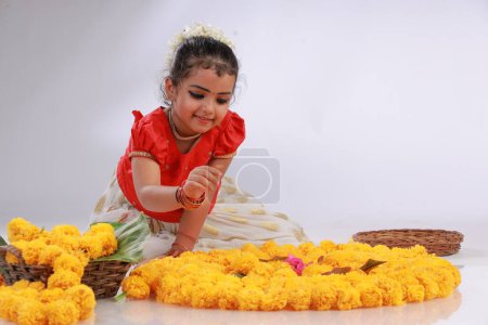 Una linda niña pequeña con vestido de Kerala de color dorado falda larga y blusa roja, tema del festival onam, fondo blanco aislado.