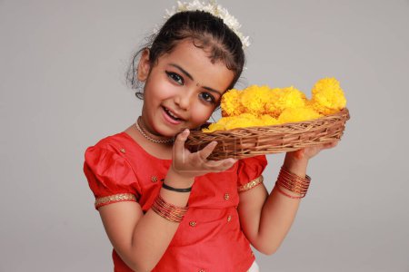 Téléchargez les photos : Une jolie petite fille enfant portant une jupe longue Kerala couleur or et chemisier rouge, thème du festival onam, fond blanc isolé. - en image libre de droit