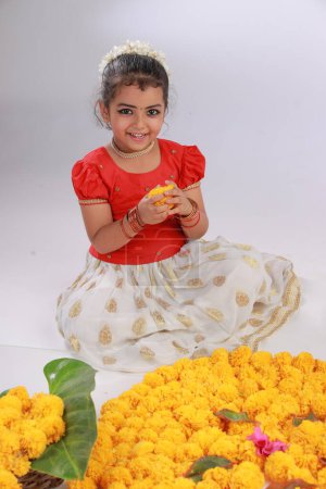 Photo for A cute small girl child wearing  Kerala dress-golden colour long skirt and red blouse,onam festival theme, isolated white background. - Royalty Free Image