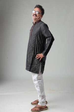 Foto de Un hombre con traje tradicional indio, con fondo liso, aislado, con kurta negra y pijama blanco. - Imagen libre de derechos